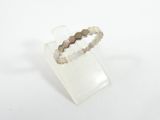 bague en argent sterling sertie de diamants taille rose, posée sur un socle en acrylique transparent
