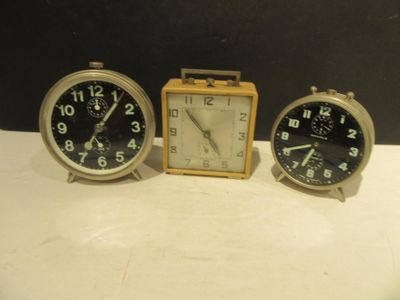trois horloges posées les unes à côté des autres sur une table
