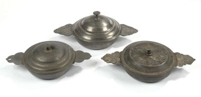 three antique pewwares on a white surface with a white background