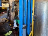 a large metal tank sitting on a lift in a garage