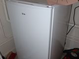 an image of a small white refrigerator in a room