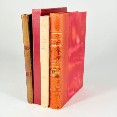 trois livres empilés sur une surface blanche