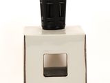 a white box with a black cup on top of it