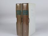 two books sitting on top of each other on a white surface