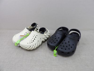 deux paires de Crocs posées par terre, l'une à côté de l'autre
