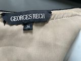 the label on the back of a beige suit with a black and white logo