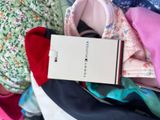 a white box with a tie on top of a pile of clothes