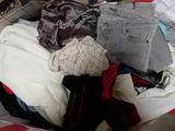 une valise remplie de vêtements posée sur un lit