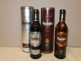 trois bouteilles d'alcool posées sur une table à côté d'un bidon