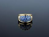 an 18k yellow gold ring set with blue sapphires and diamonds
