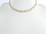 un gros plan sur le torse d'un mannequin portant un collier à chaîne en or