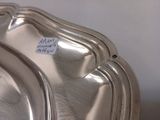 une assiette en argent sur laquelle est collé un autocollant