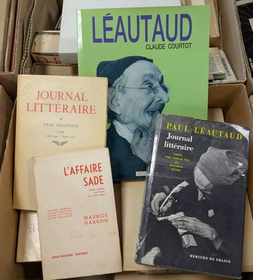 several books in a cardboard box on top of a pile of books