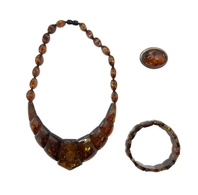necklace, bracelet, and ring with a picture of a woman ' s face on a white background