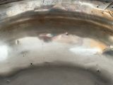 an antique silver plate on a table with a black background