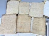 Plusieurs vieux manuscrits sont empilés les uns sur les autres sur une table