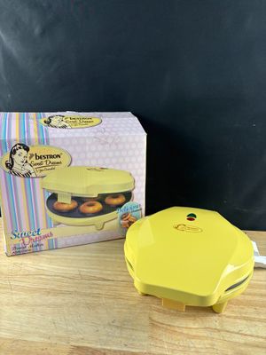 un gros plan sur une boîte de beignets posée sur une table, avec une autre boîte de beignets en arrière-plan