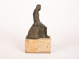statue of a woman sitting on a stone block with a white background