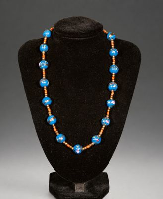a blue and orange beaded necklace on a black mannequin