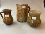 trois vases posés sur une table, sur lesquels sont apposées des étiquettes