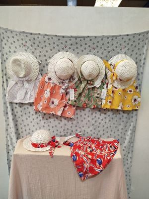 many hats on a table with a cloth on top of it