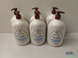 trois flacons de gel douche posés sur un plan de travail