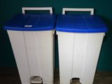 two white and blue trash cans sitting next to each other on a wooden floor