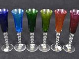 six different colored wine glasses are lined up in a row