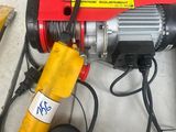 un palan électrique rouge et jaune posé sur une table