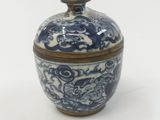 a blue and white bowl with a lid on a white surface