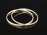 a close up of two gold rings on a black surface