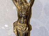 une statue en or représentant une personne suspendue à une corde