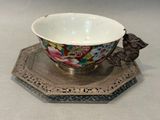 a silver plate with a bowl on it and a bird figurine on it