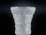 vase en verre translucide posé sur une surface noire, avec un fond noir