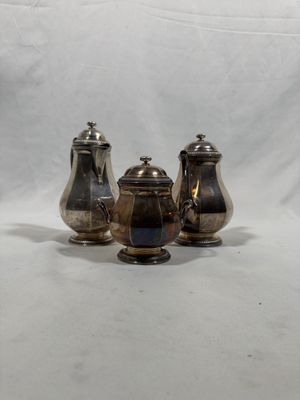 trois théières en métal argenté et un sucrier sur fond blanc