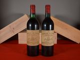 two bottles of red wine sitting next to each other on a table