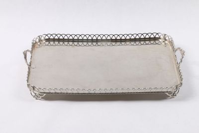 un plateau argenté avec une poignée sur une surface blanche