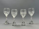 quatre verres à vin transparents posés sur une table