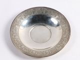 a silver plate with a design on it on a white surface