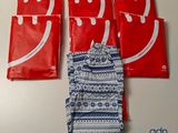 quatre sachets rouges et blancs sur lesquels est dessiné un sourire
