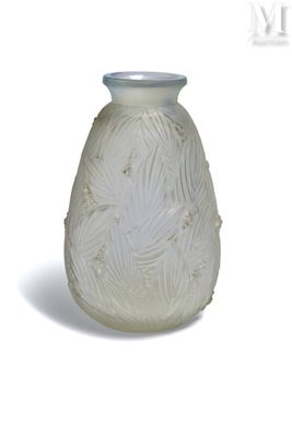 a white vase that has a leaf design on it