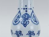 a blue and white vase sitting on a white surface