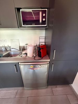a small kitchen with a microwave, dishwasher, and a dishwasher