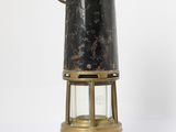 an old fashioned brass and glass lantern on a white surface