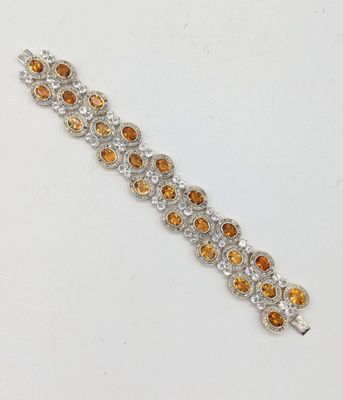un gros plan sur un bracelet orné de pierres orange et blanches