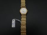 un gros plan d'une montre-bracelet en or sur laquelle est accrochée une étiquette