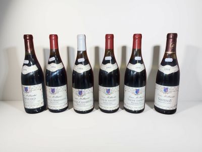 six bouteilles de vin sont alignées sur une table