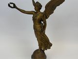 une image représentant une statue en bronze d'un ange tenant un oiseau