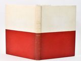 a red and white book sitting on top of a white table