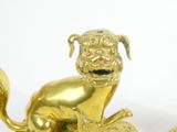 a gold statue of a dog sitting on a plate